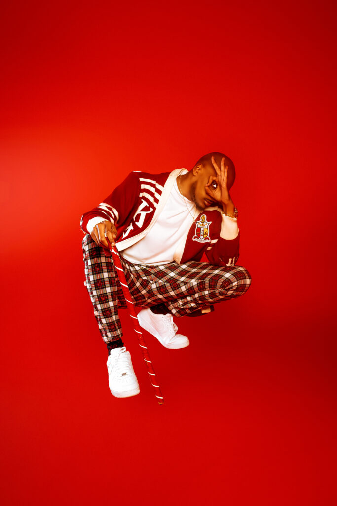 Editorial studio portrait against a vivid red background