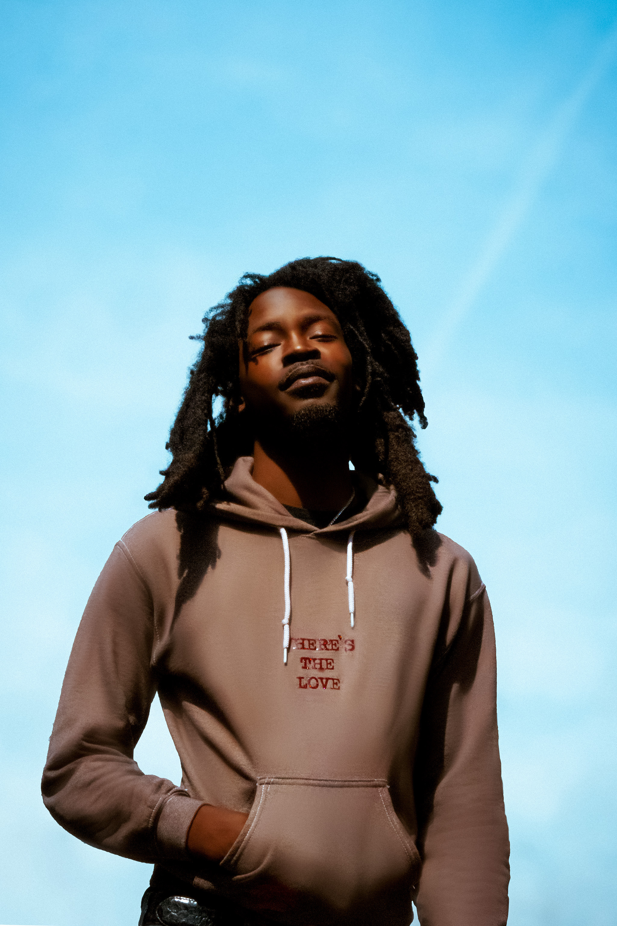 Low-angle outdoor portrait against a blue sky